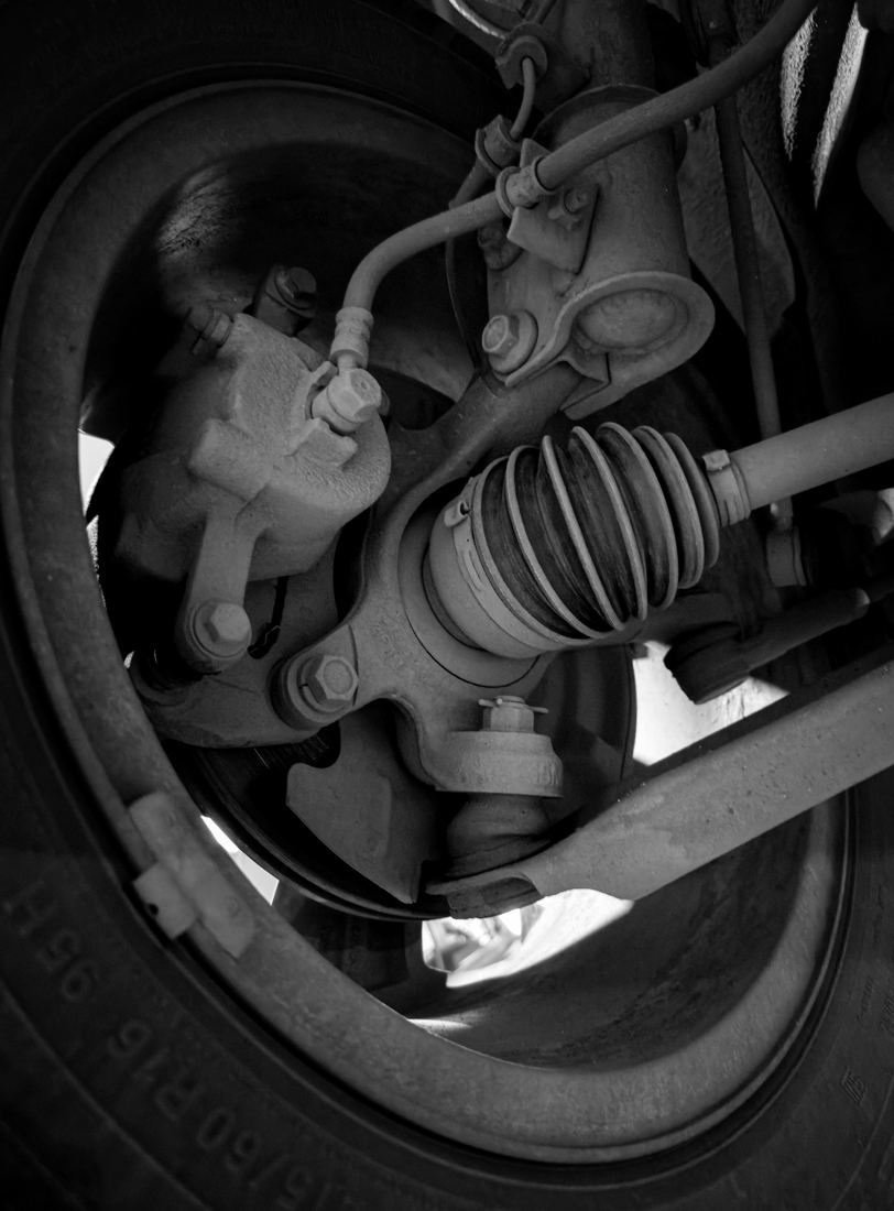 Close-up of a car's suspension and axle behind the wheel