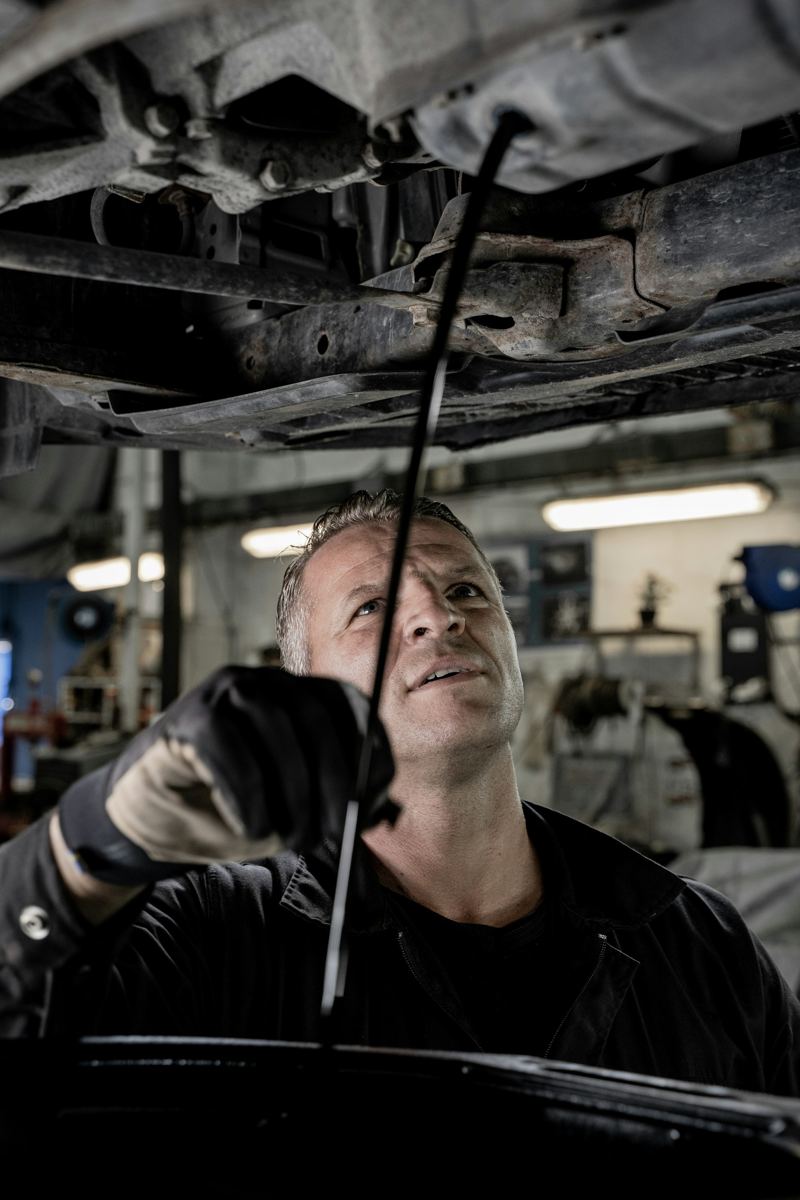 Mechanic inspecting the underside of a car on a lift