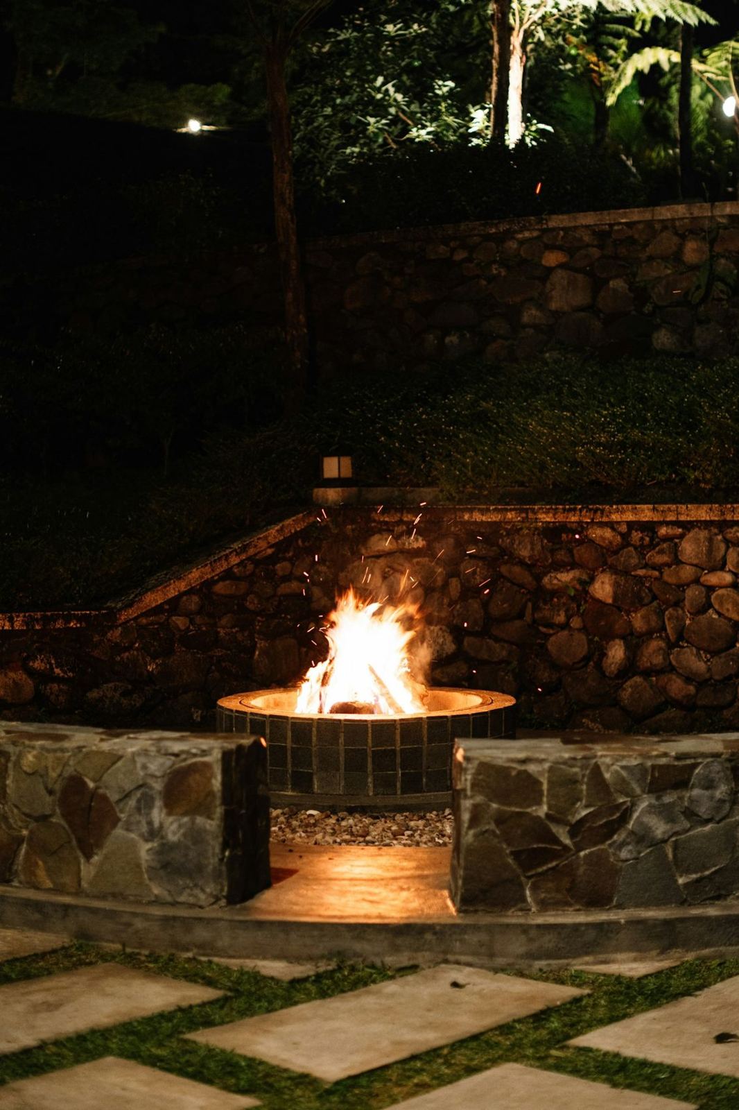 Stone fire pit and paver patio at night