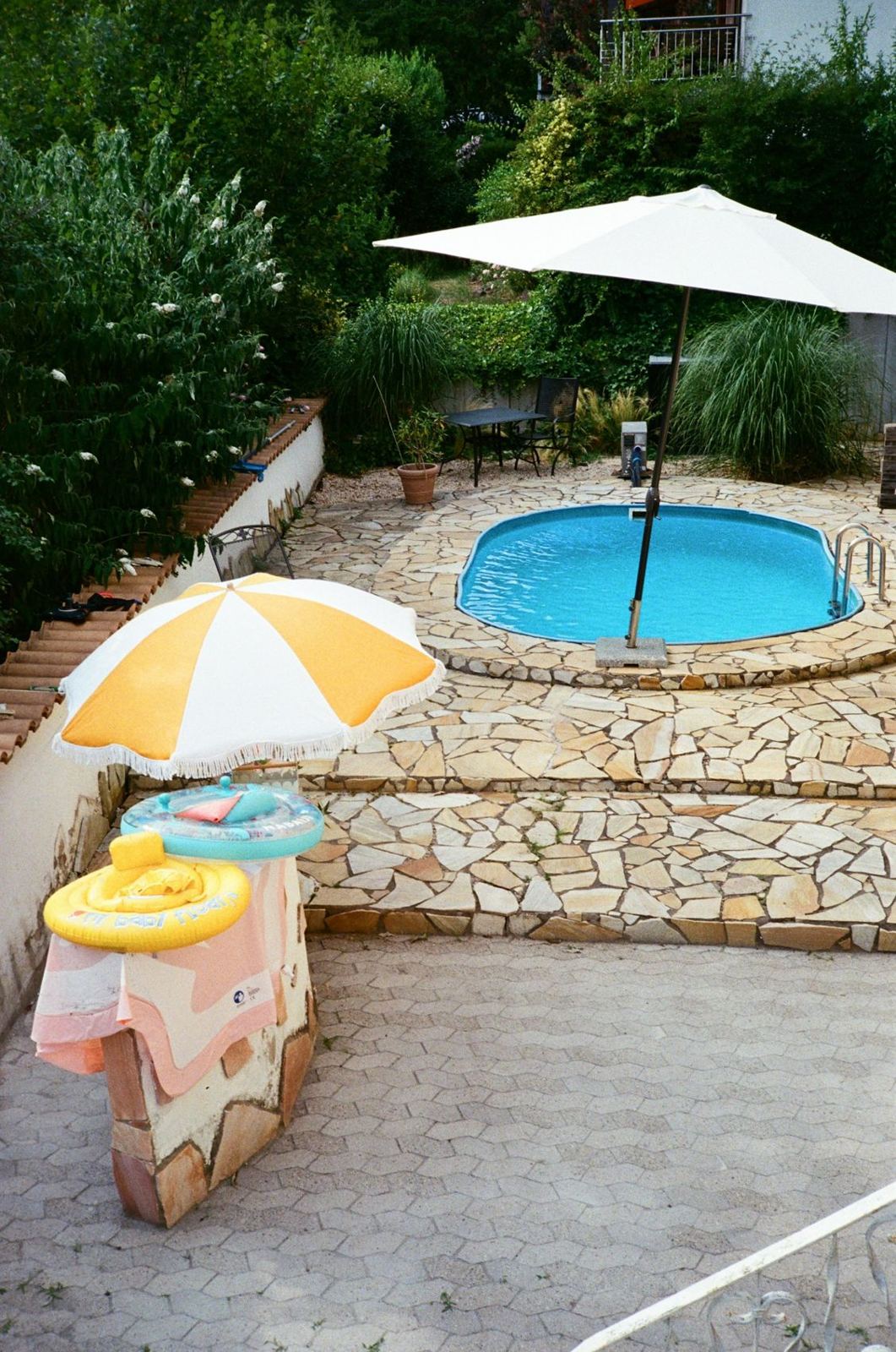 Stone pool deck around a backyard pool